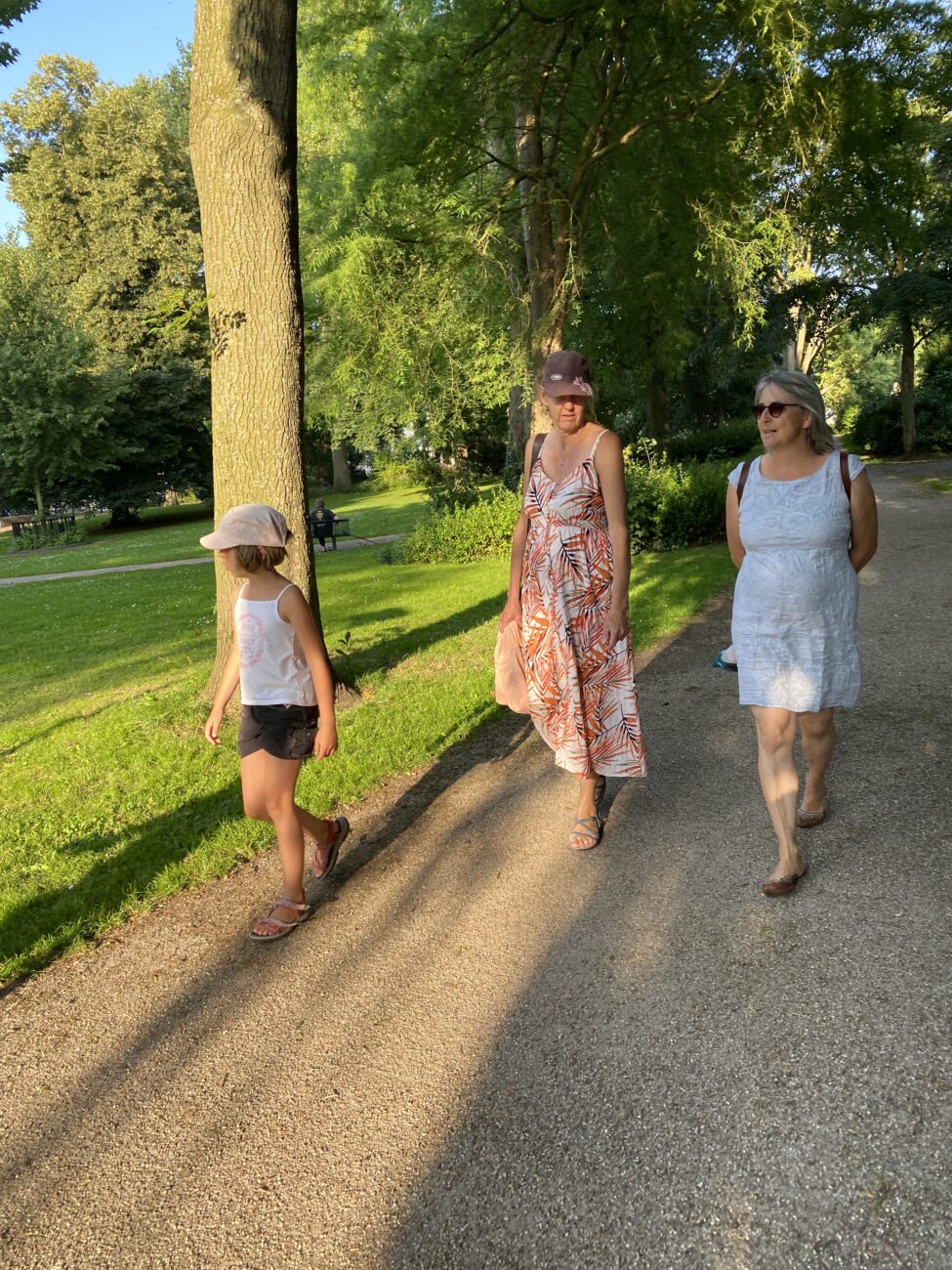 Mädchen und zwei Frauen laufen durch einen Park