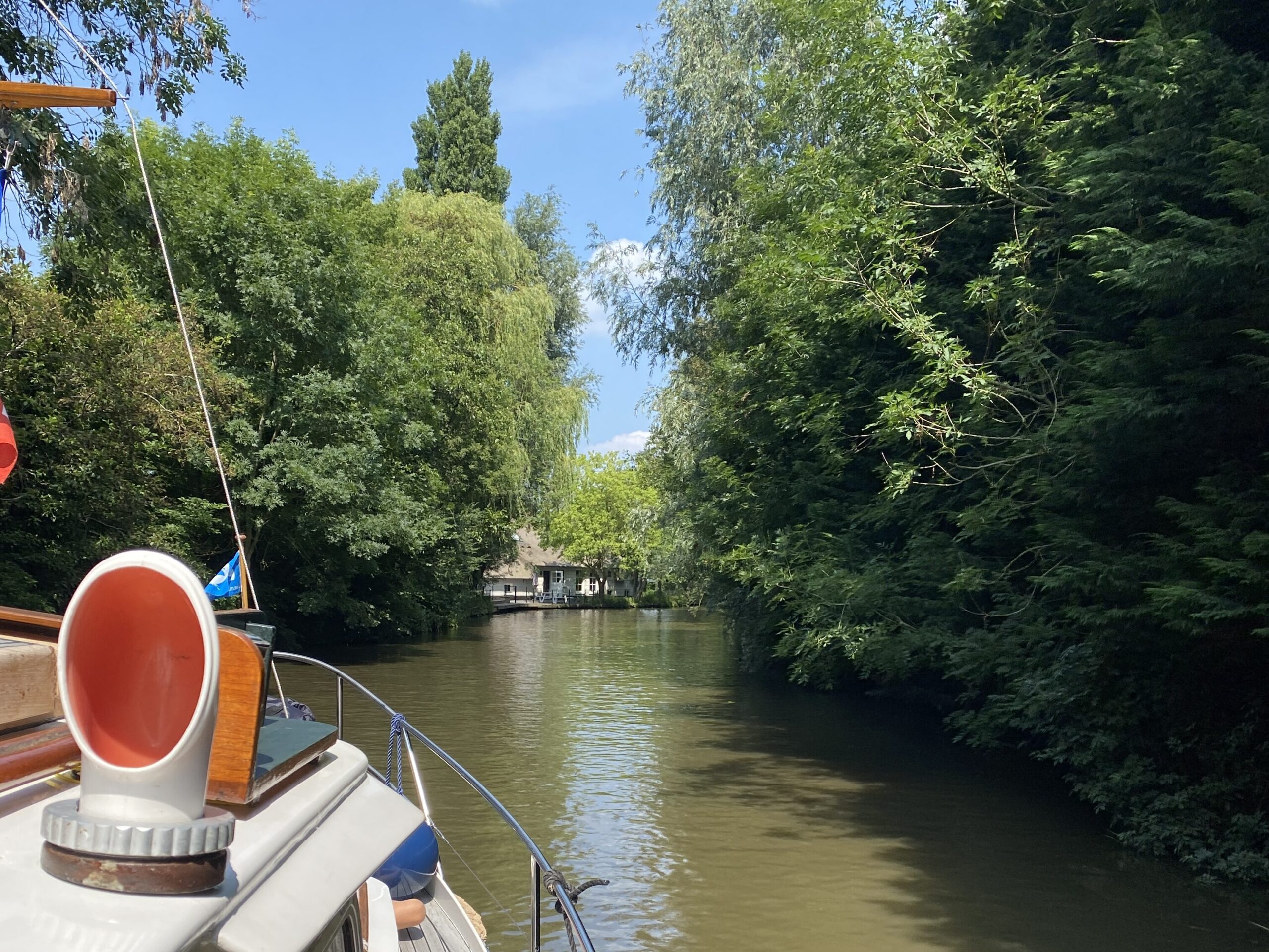 Boot fährt durch bewaldeten Kanal