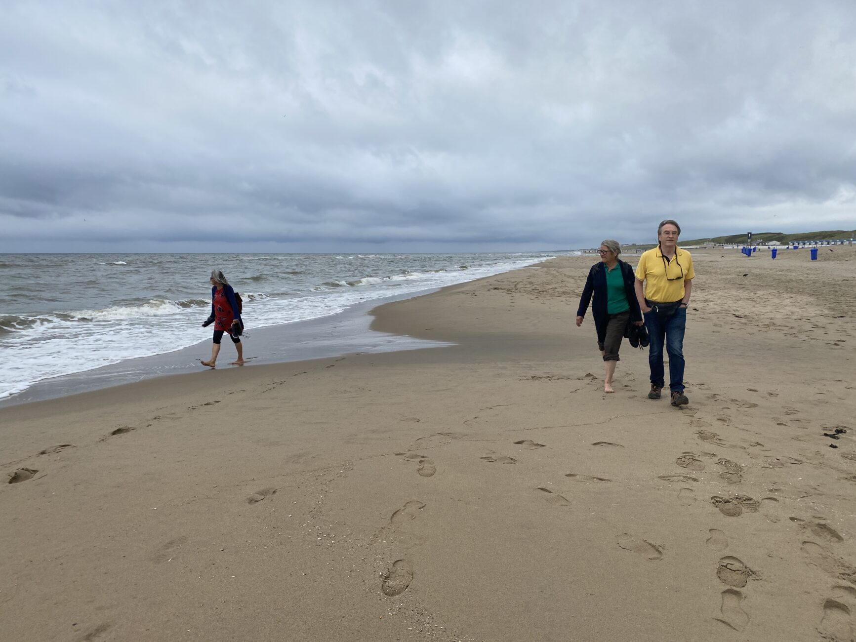 Leute spatzieren am Strand
