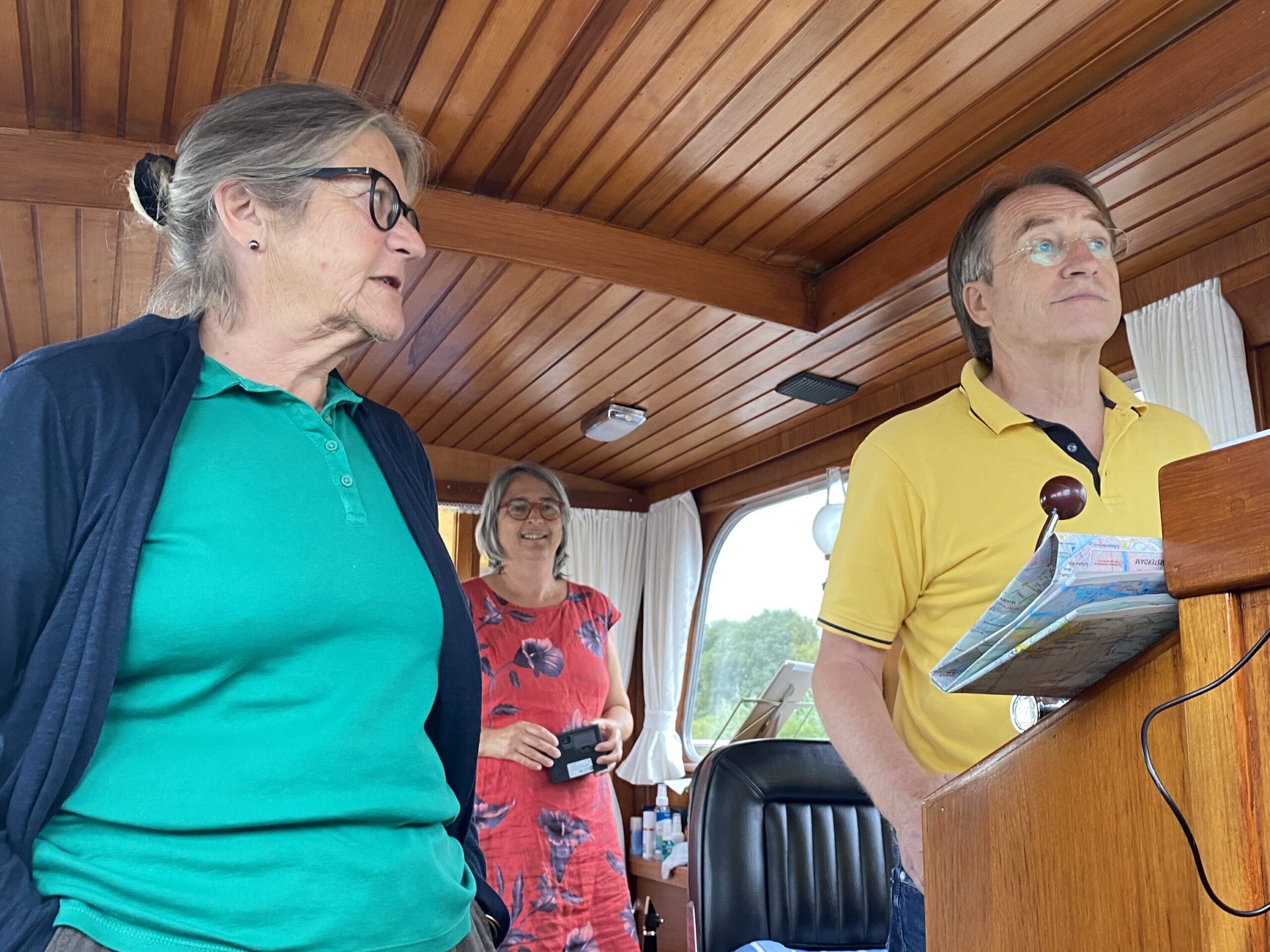 ein Mann zwei Frauen stehen im Schiff un konzerntrieren sich nach vorne